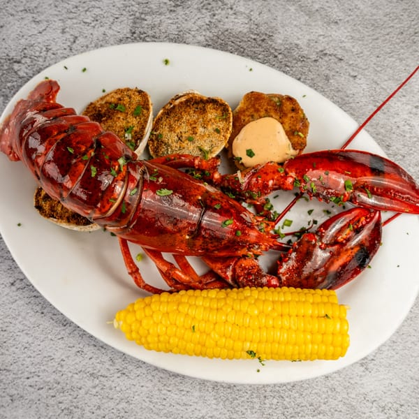 A Tres Palms seafood platter with a whole lobster, baked clams, and corn on the cob.
